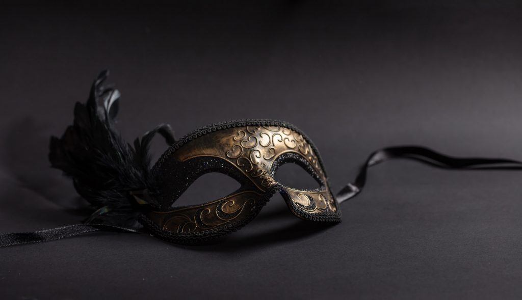 Carnival mask with feathers on black background